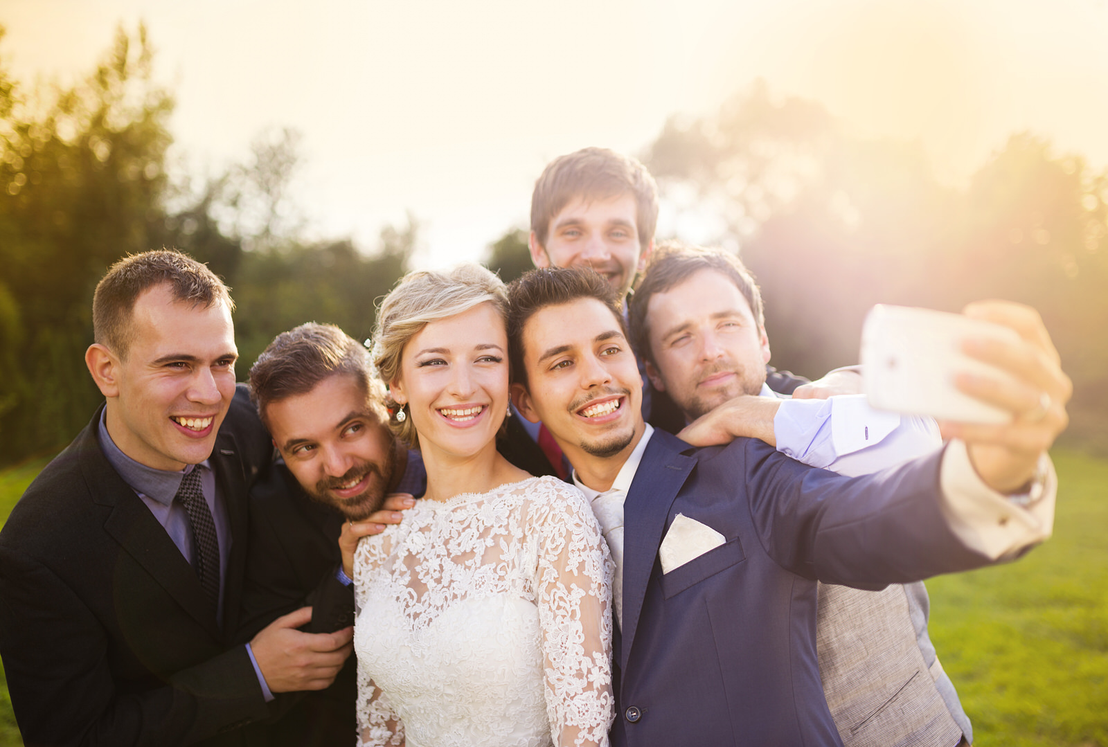 Bride with groom and his friends taking selfie Outdoor portrait of beautiful young bride with groom and his friends taking selfie